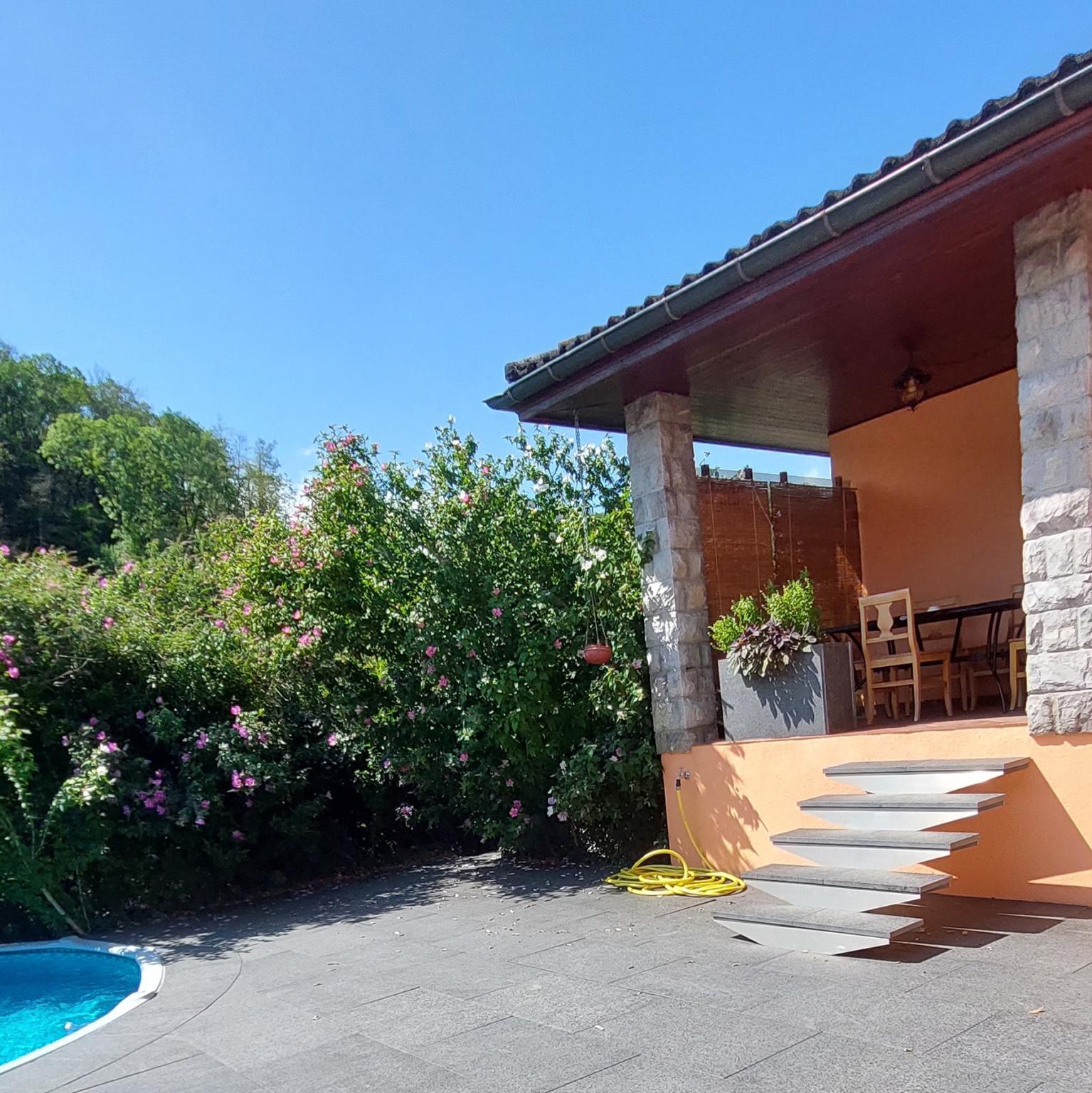 Außenbereich mit Pool und überdachter Terrasse