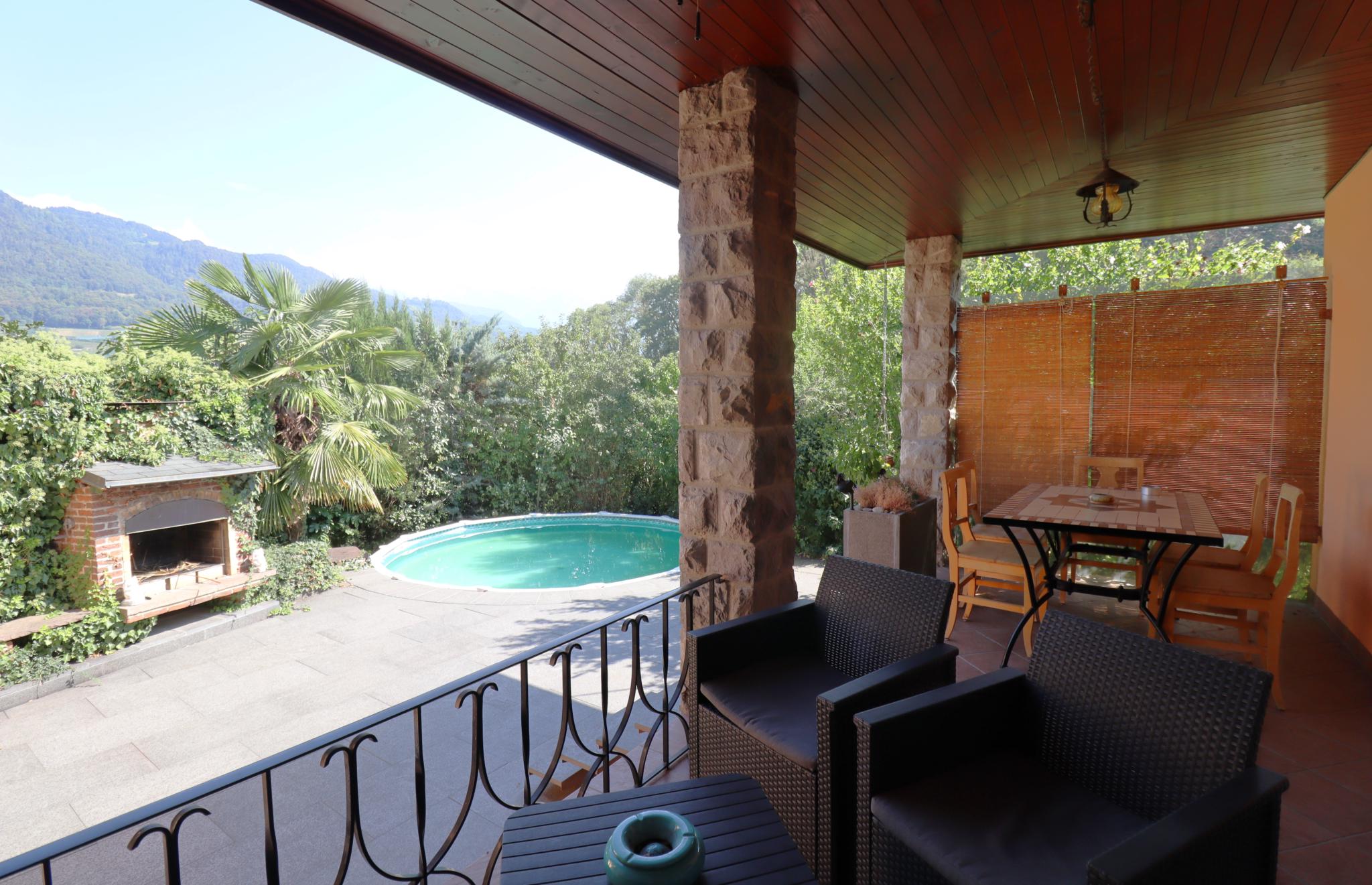 Überdachte Terrasse mit Poolblick