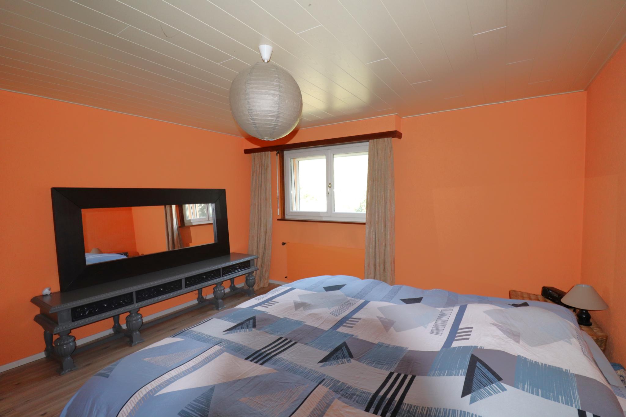 Schlafzimmer mit orangefarbenen Wänden