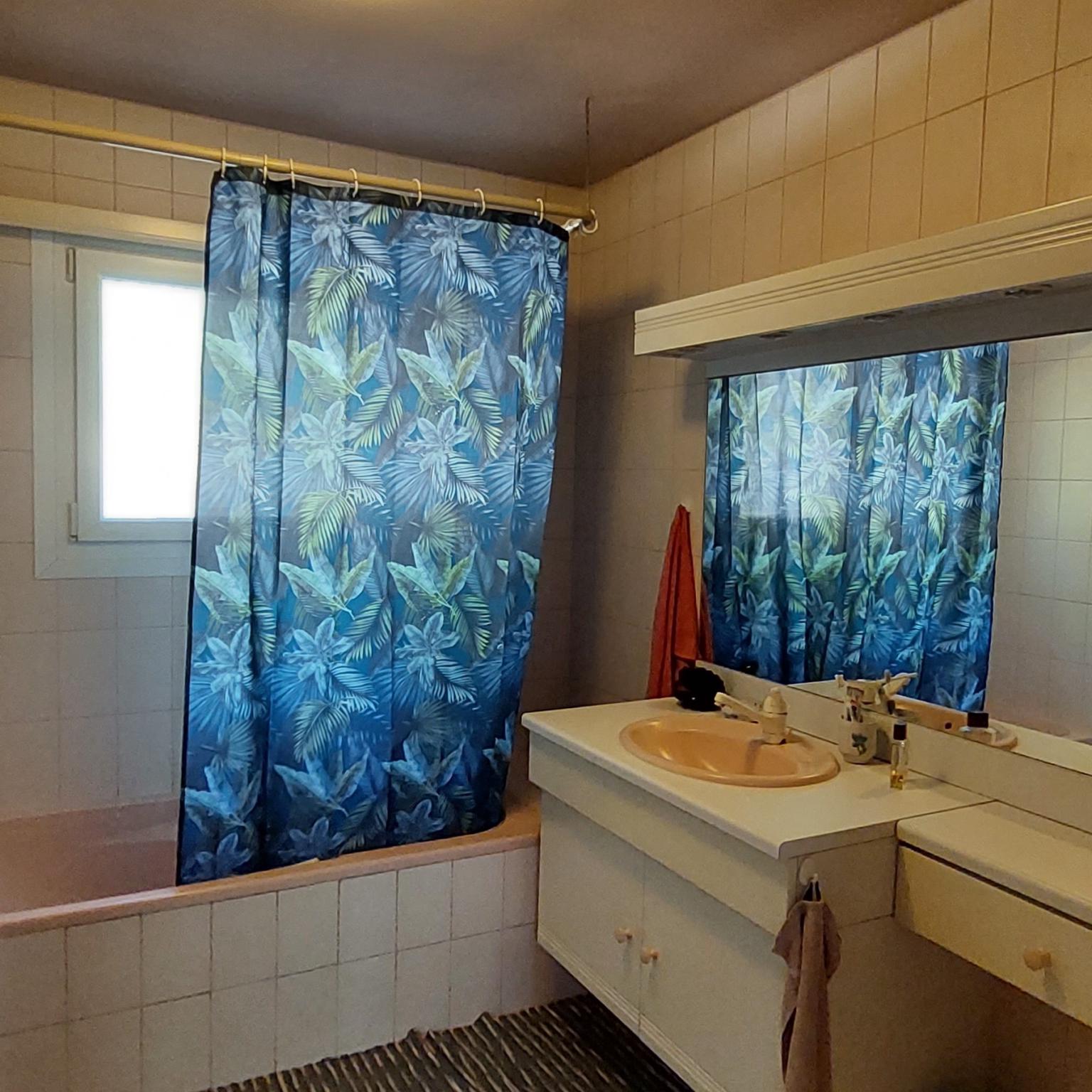 Badezimmer mit tropischem Duschvorhang