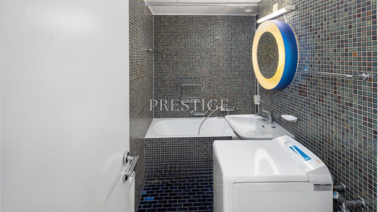 Kleines Badezimmer mit Badewanne und Waschmaschine