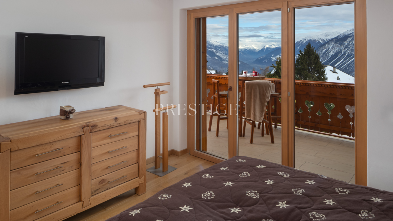 Schlafzimmer mit Balkonblick auf die Berge