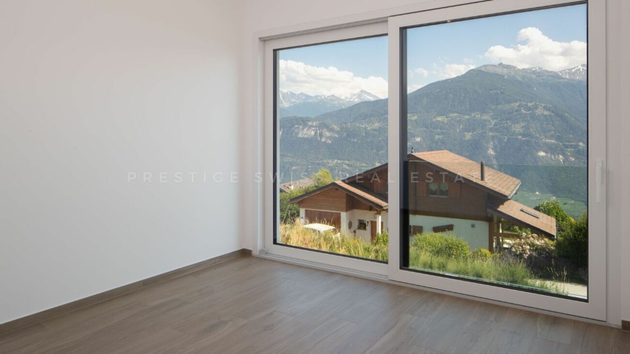 Leerer Raum mit großem Panoramafenster und Bergblick