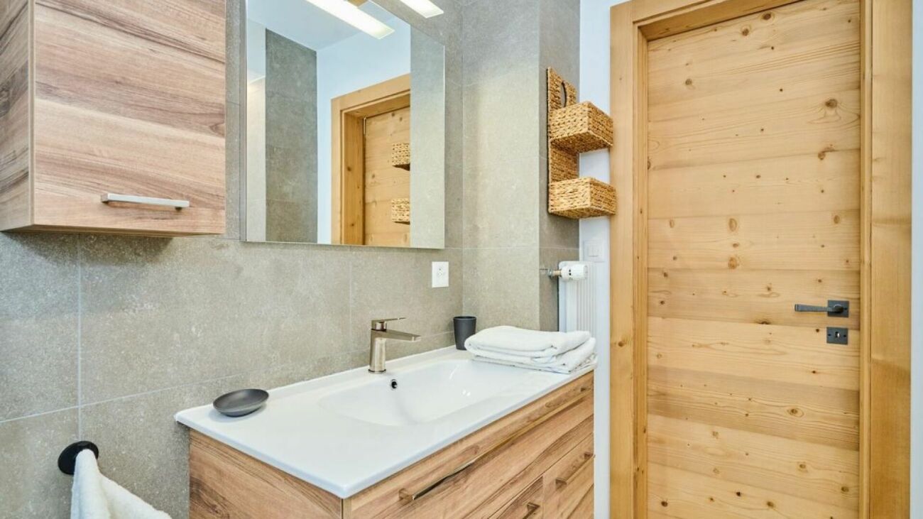 Modernes Badezimmer mit Holztür und Steinoptik