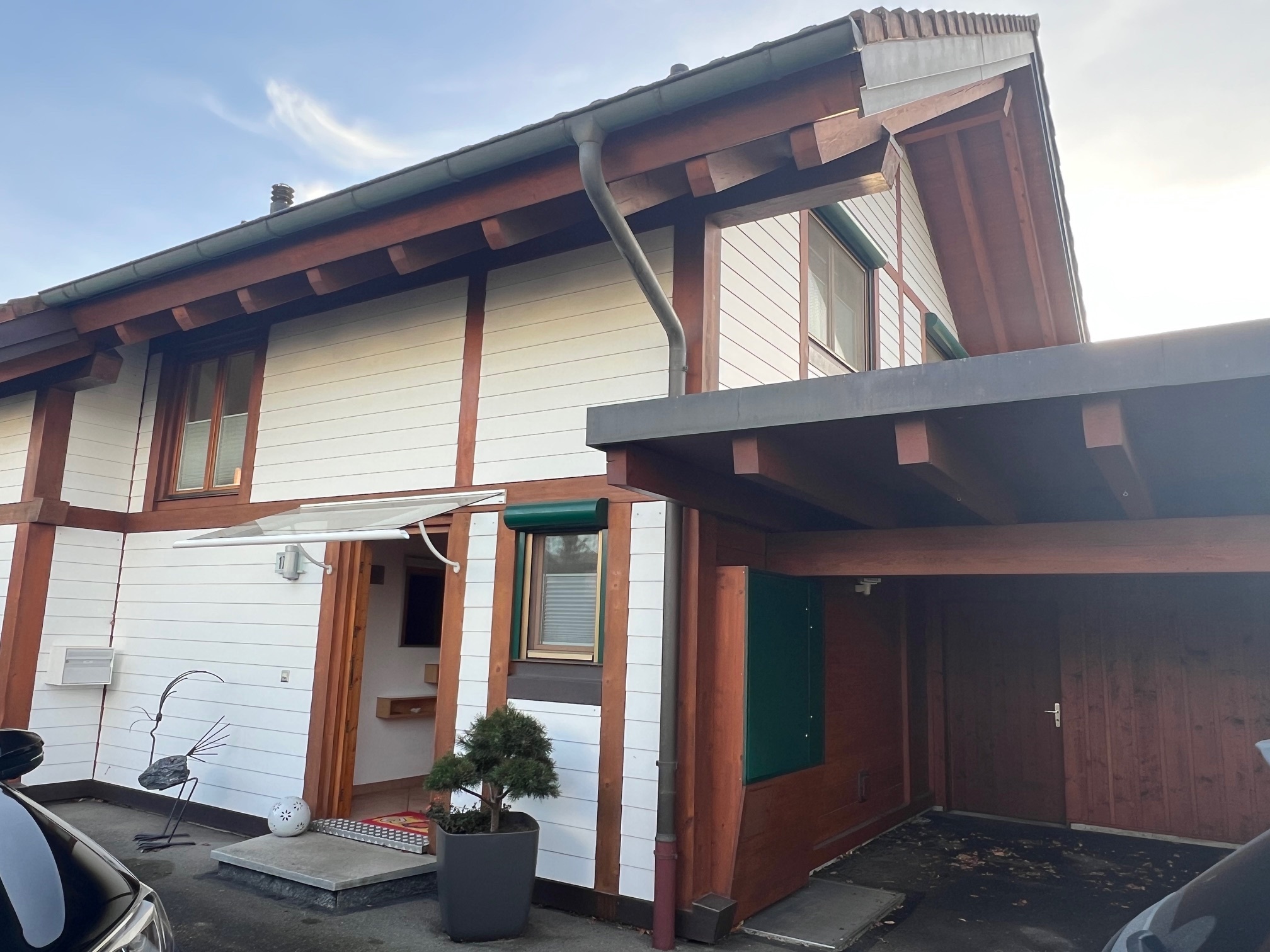 Außenansicht eines zweigeschossigen Hauses mit Holzdetails