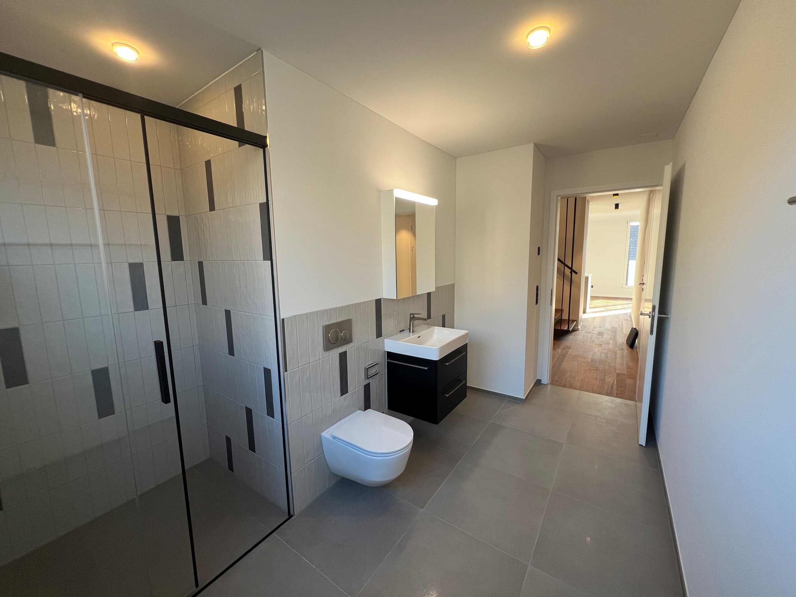 Modernes Badezimmer mit Duschzone und wandhängendem WC