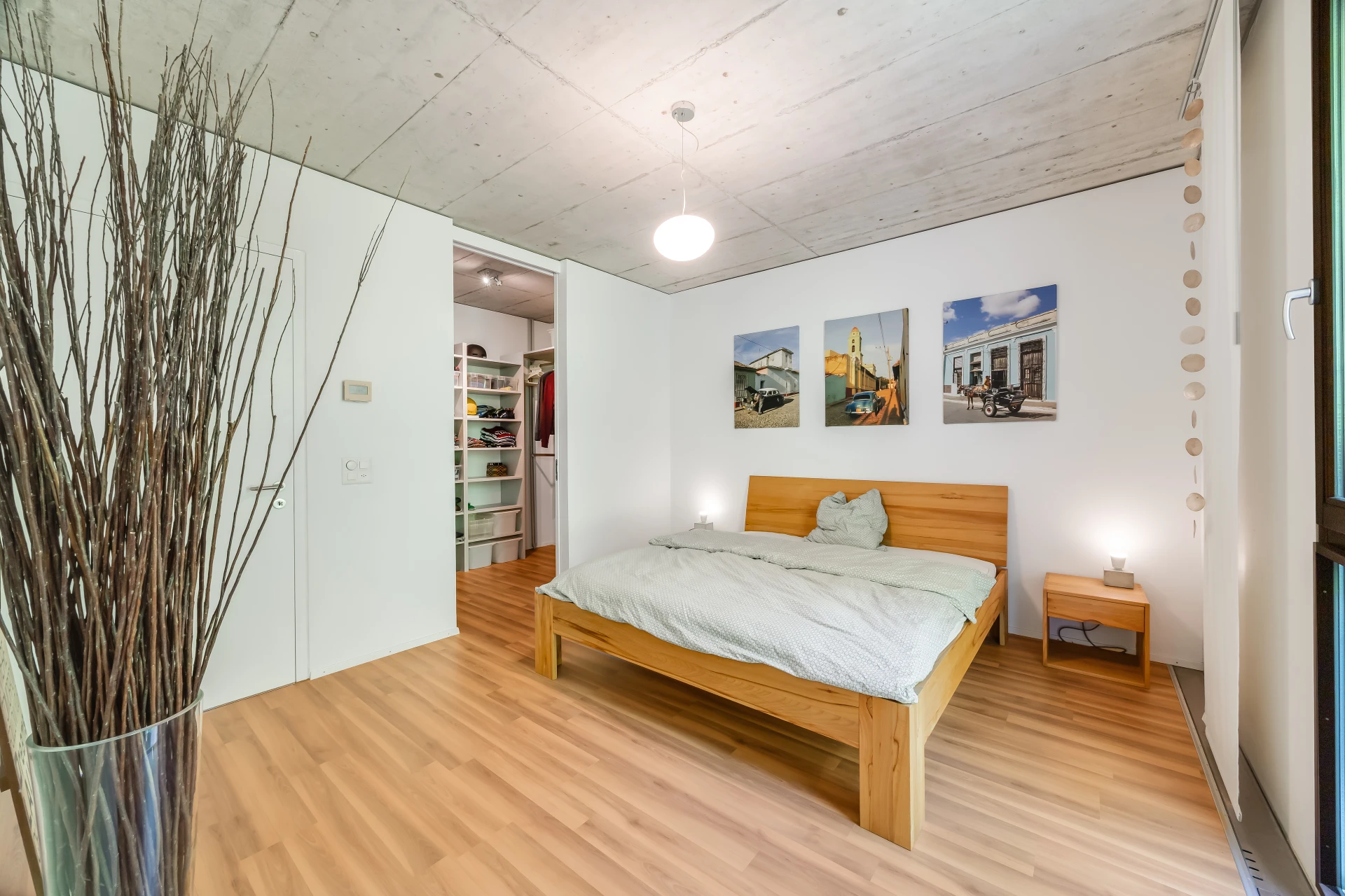 Modernes Schlafzimmer mit Holzbett und Betondecke