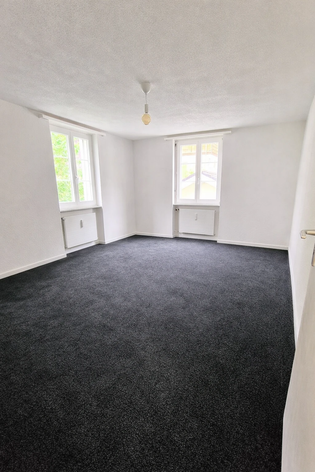 Leeres, helles Zimmer mit Teppichboden