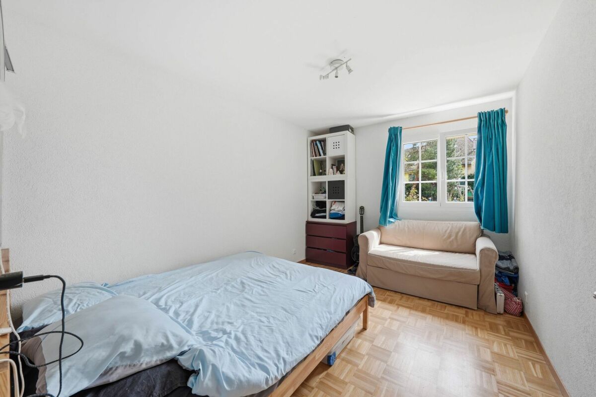 Schlichtes Schlafzimmer mit Sofa und Fenster