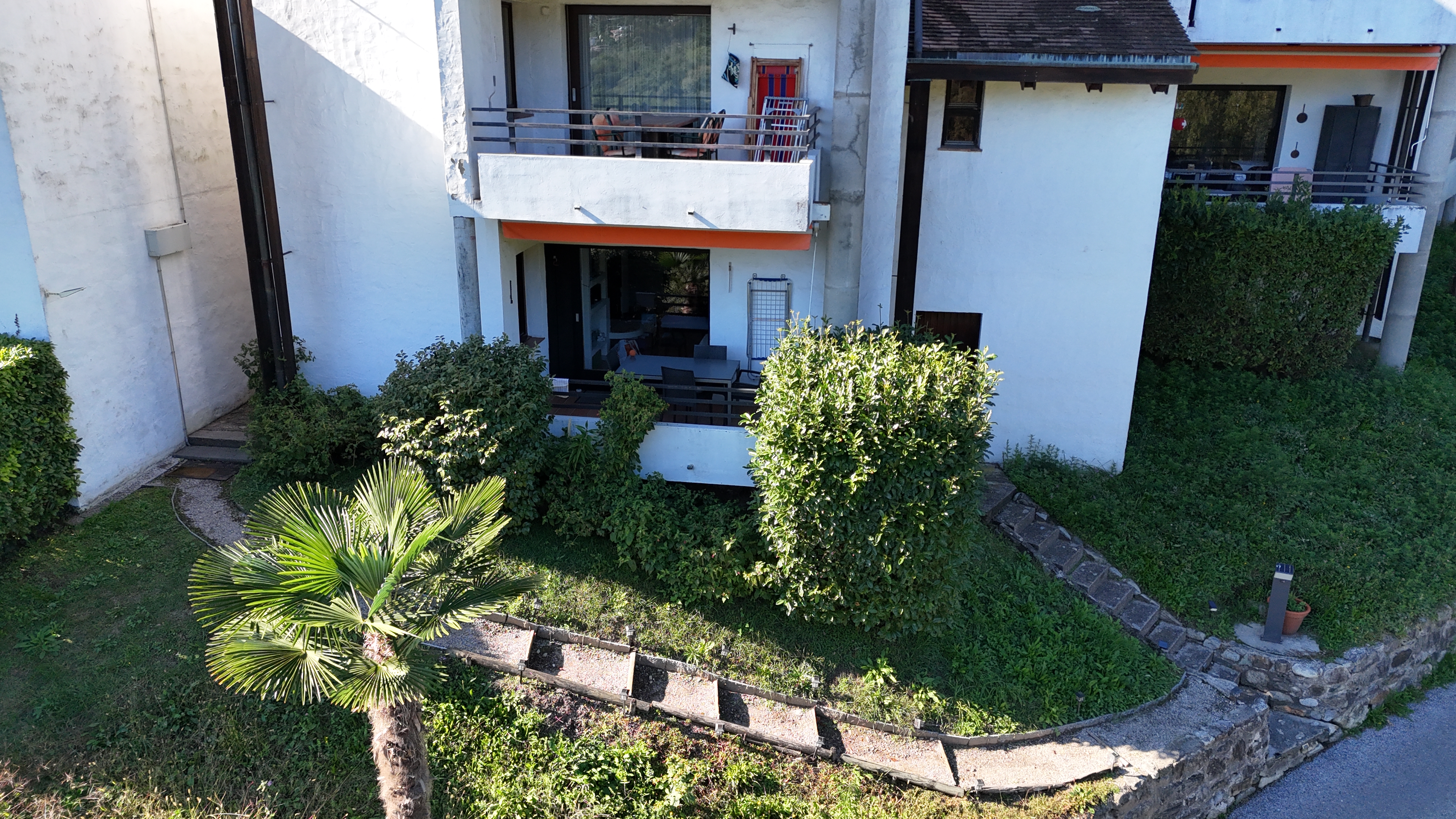 Außenansicht einer Wohnanlage mit Balkon und Garten