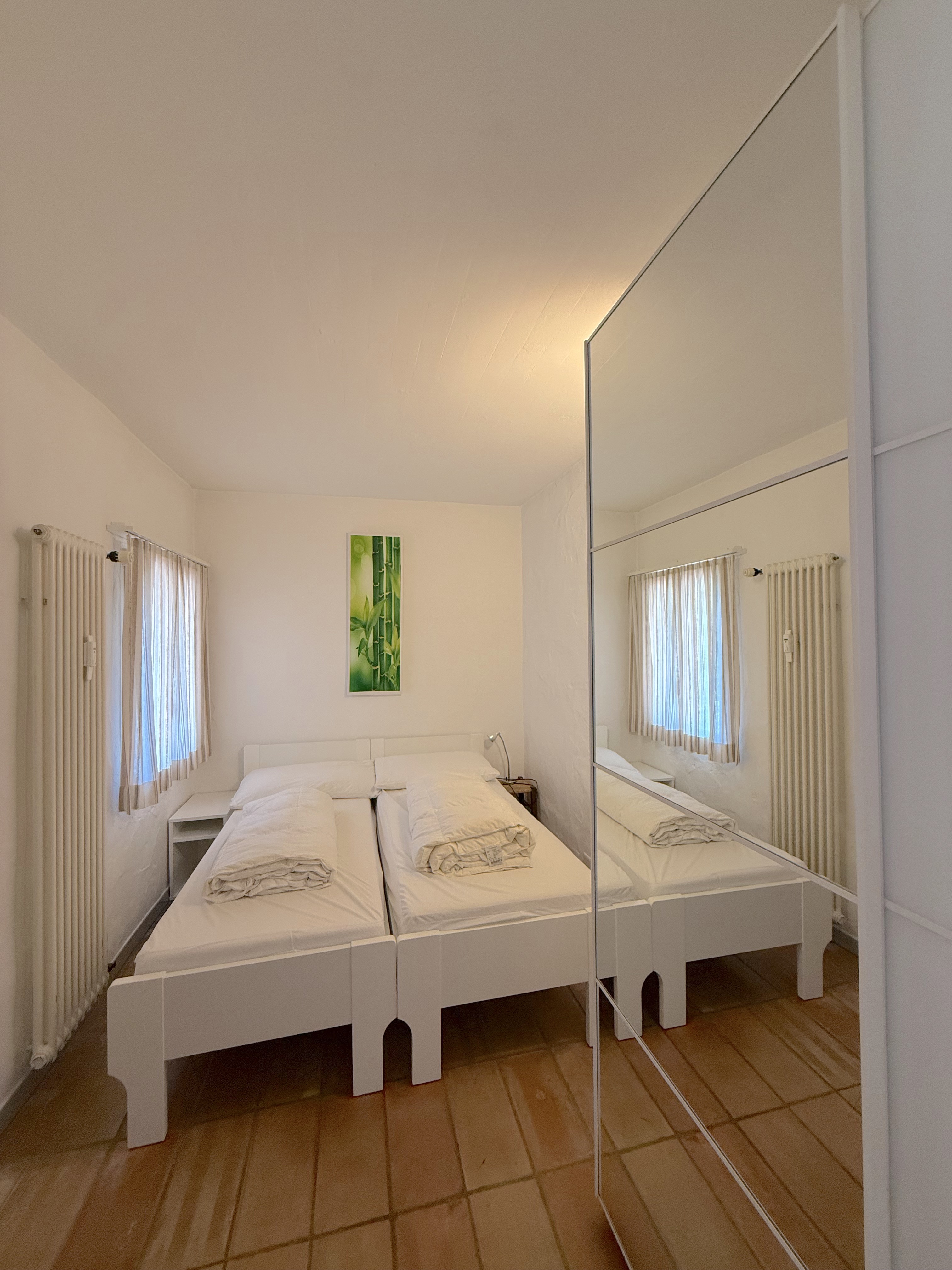 Helles Schlafzimmer mit Doppelbett und großem Spiegelschrank