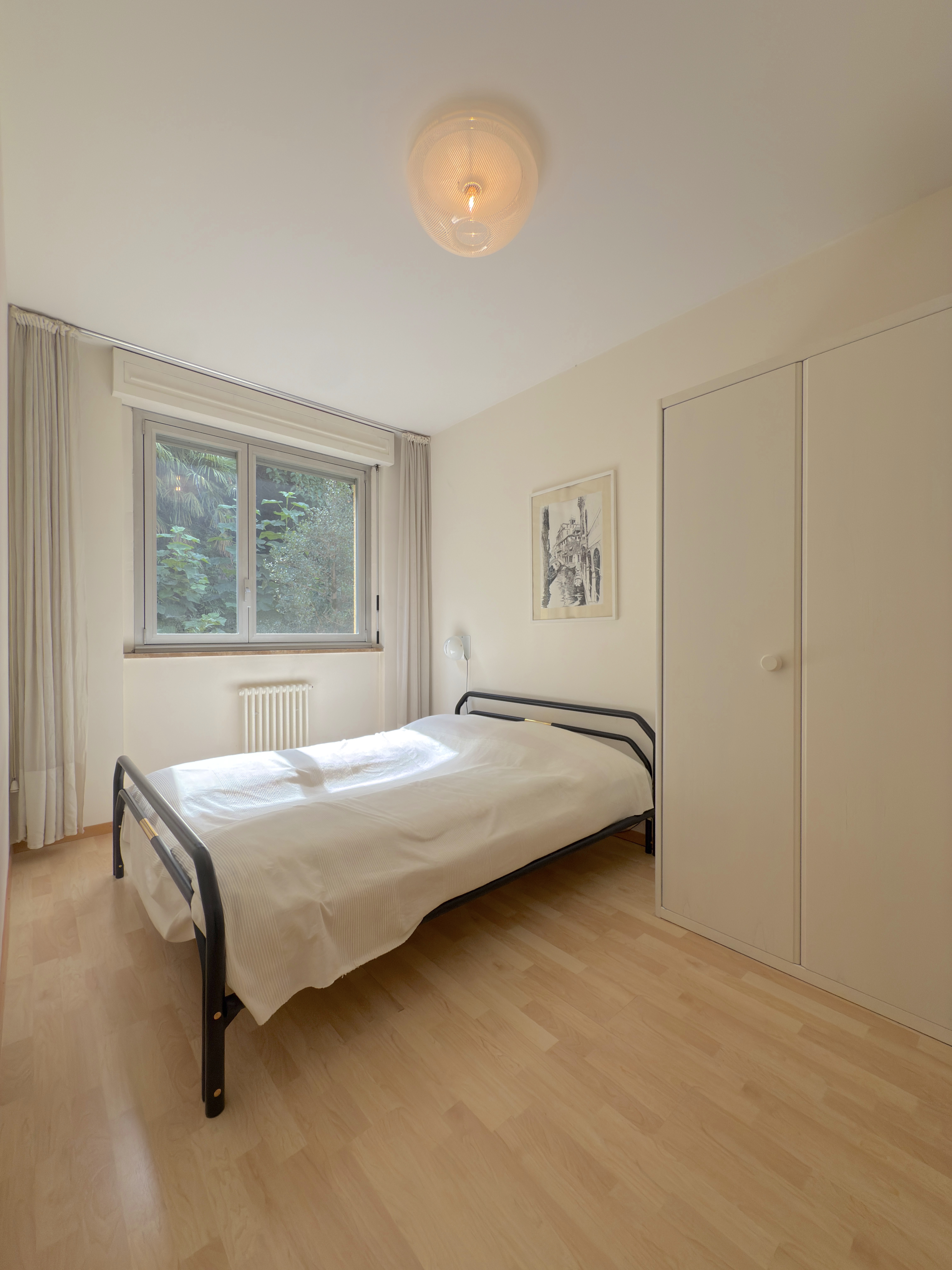 Helles Schlafzimmer mit Fenster und Einbauschrank