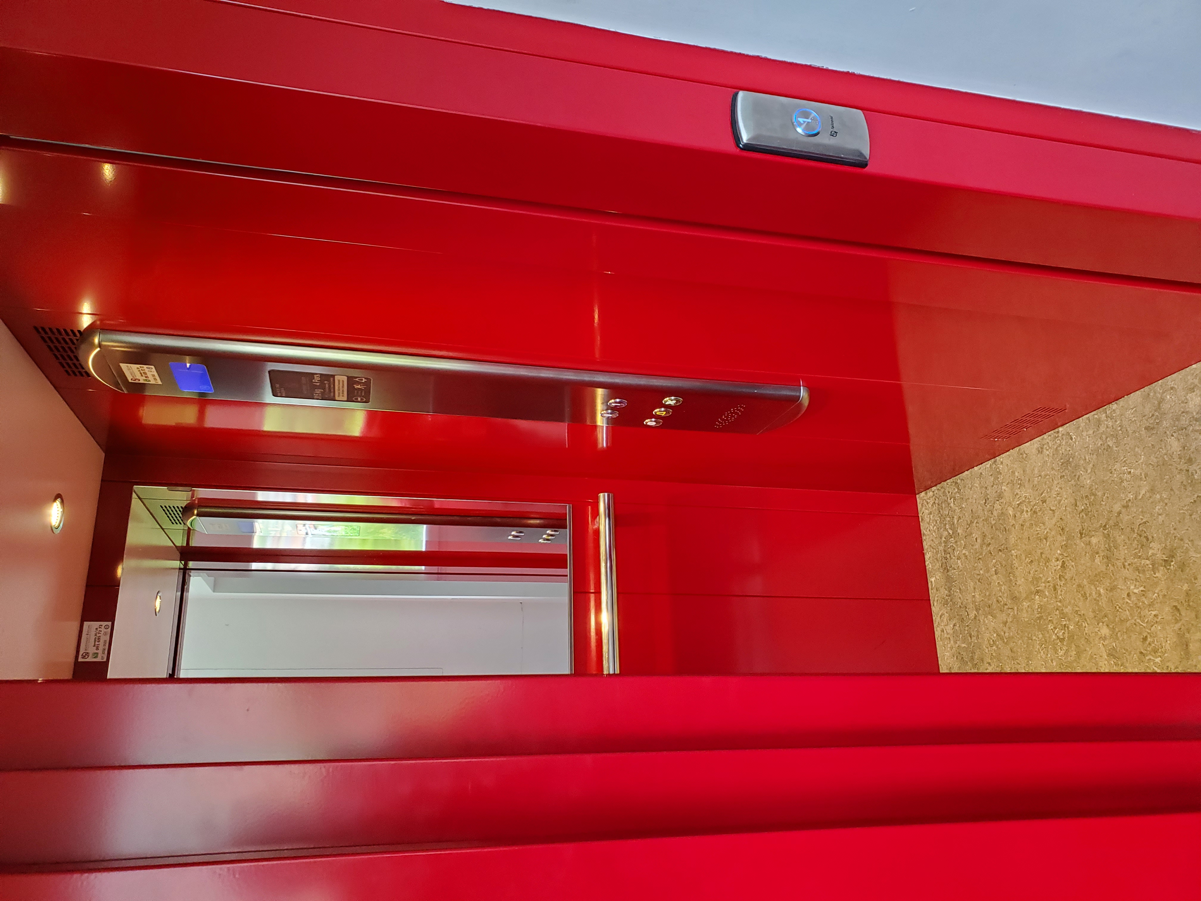 Moderner Aufzug mit roter Kabinenverkleidung