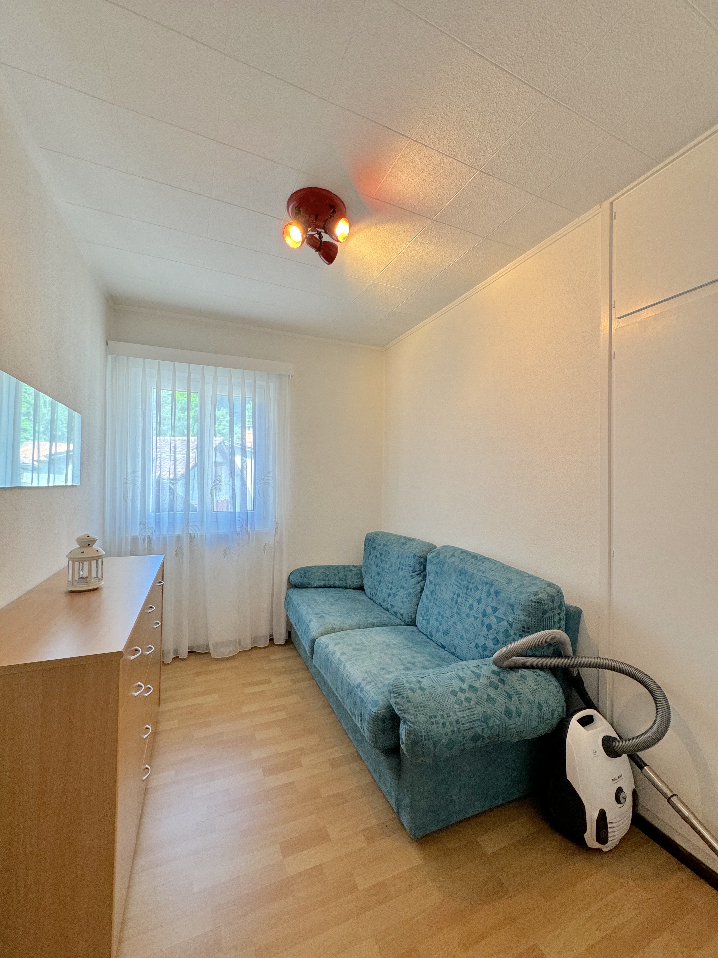 Kleiner Wohnraum mit Sofa und Schrank