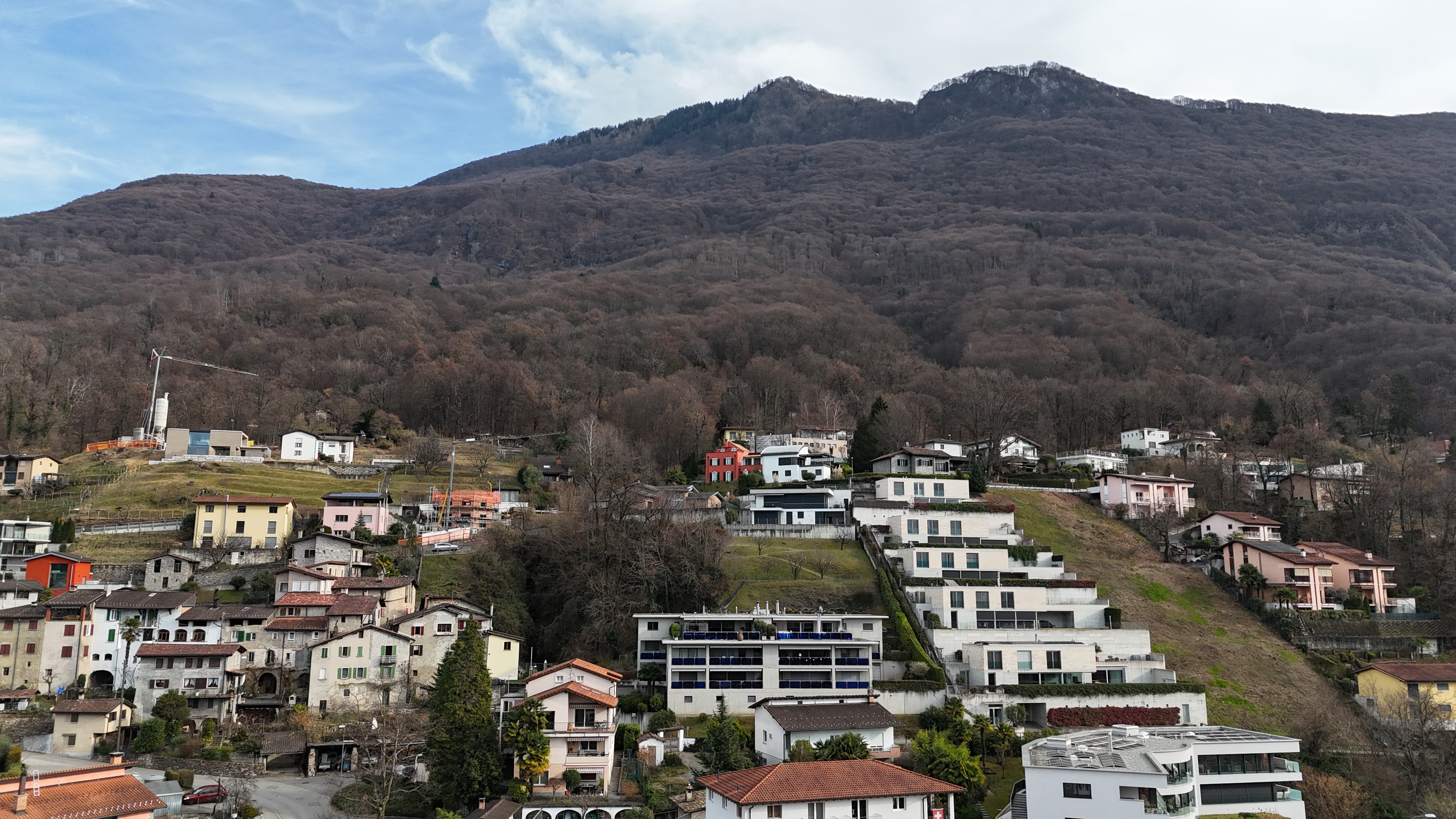 Bergsiedlung mit Häusern unter steilem Hang