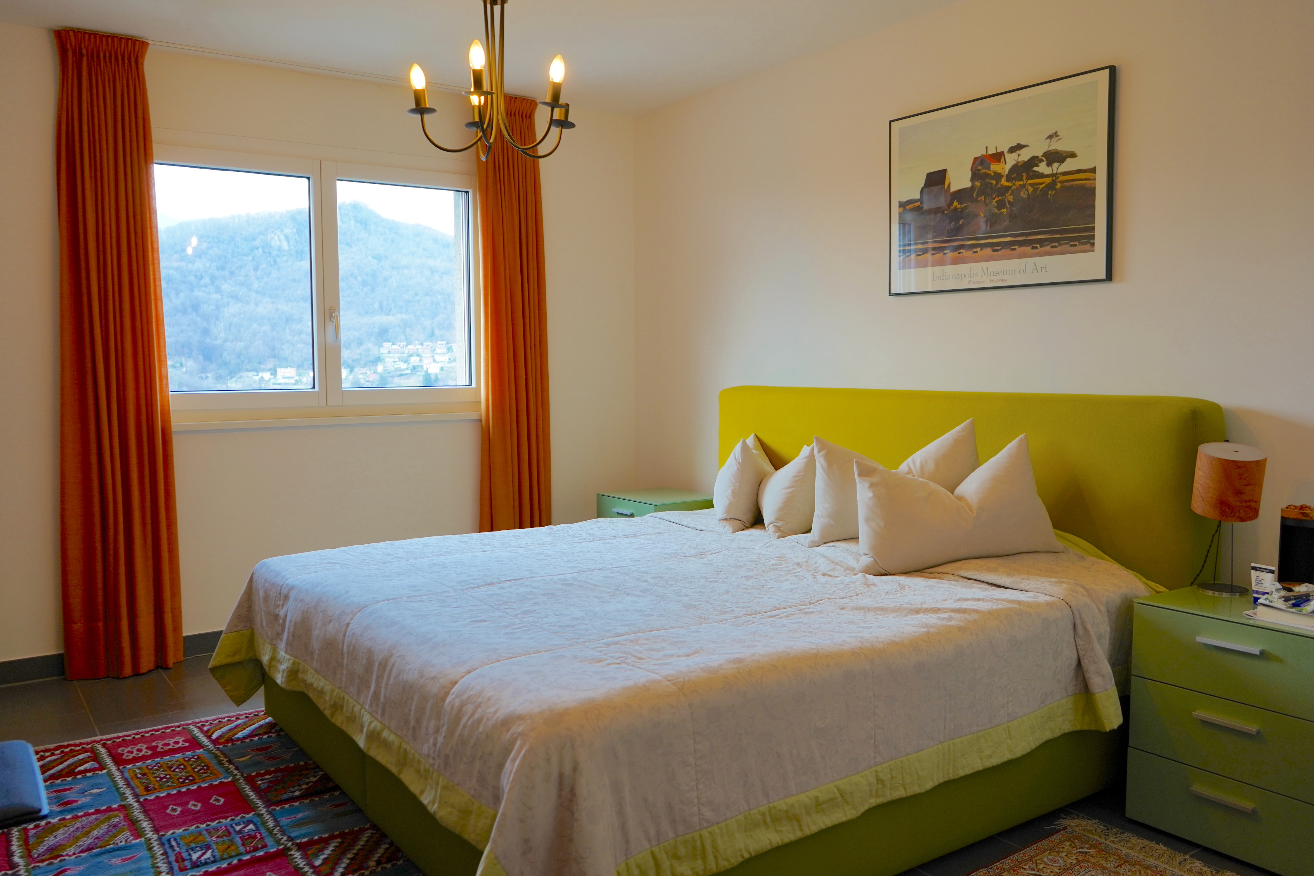 Gemütliches Schlafzimmer mit farbigen Akzenten und Bergblick