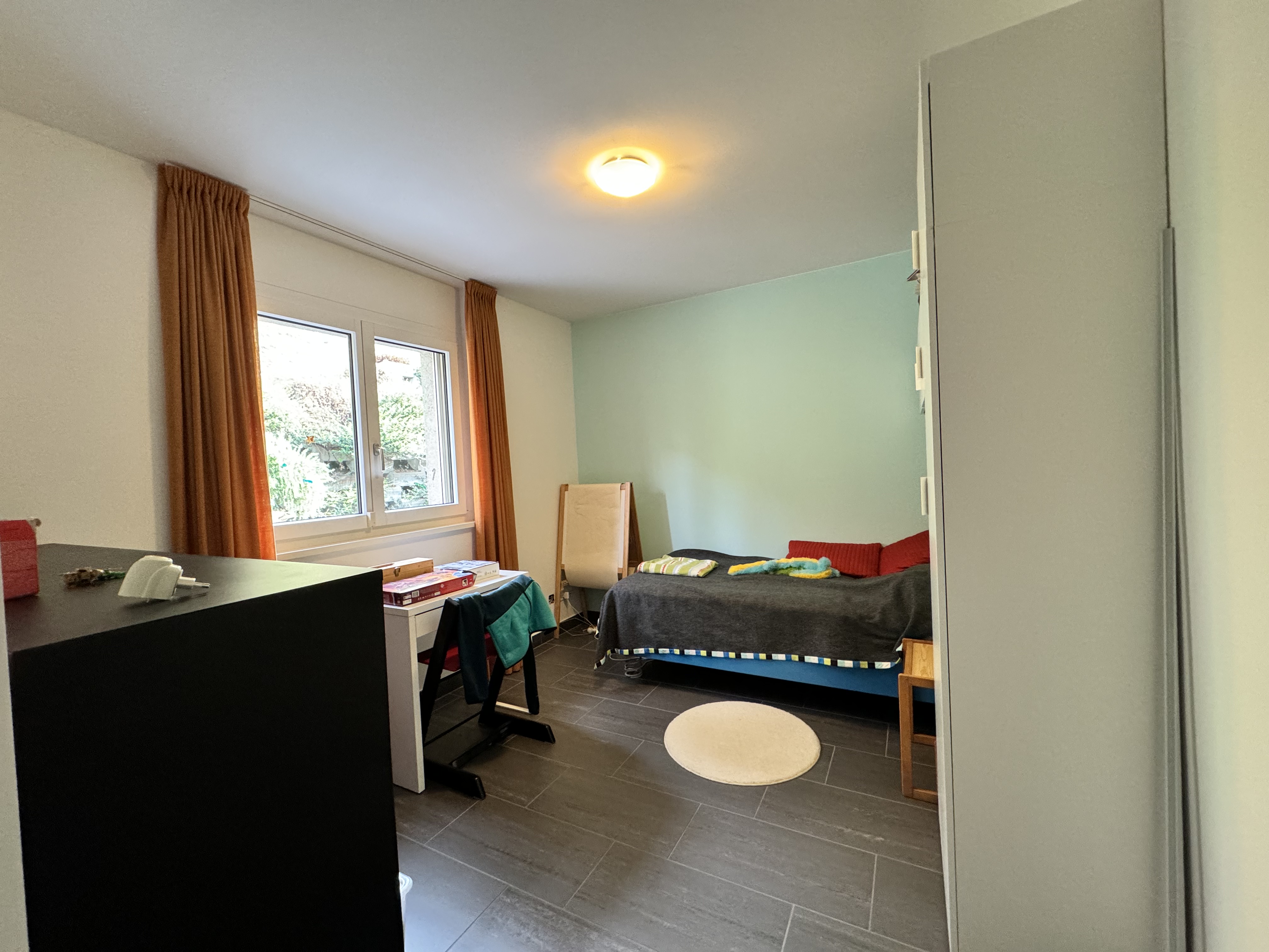Kleines Schlafzimmer mit Fenster und Bett