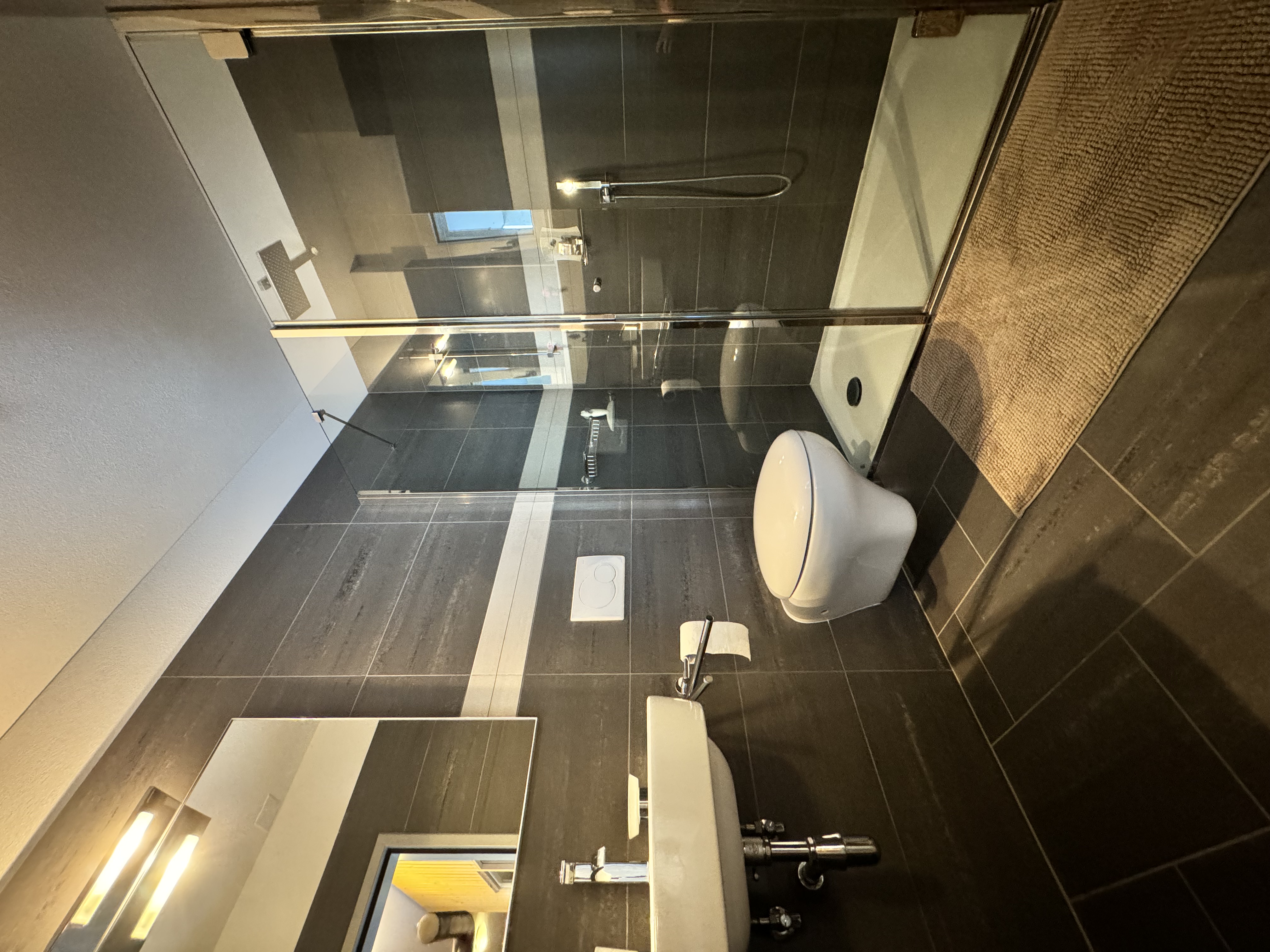 Modernes Bad mit Glasdusche und WC