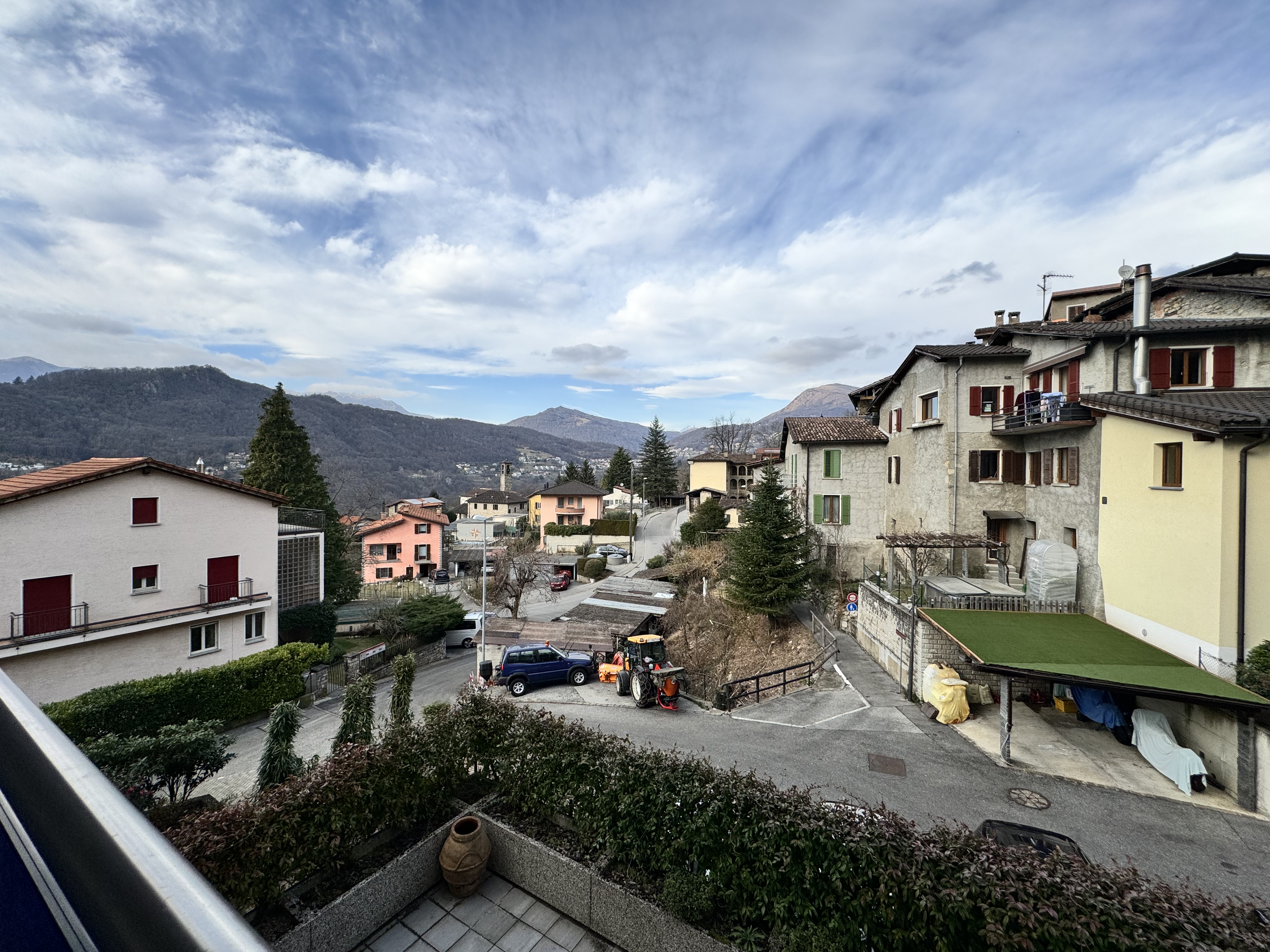 Blick über ein Hangdorf mit Bergkulisse