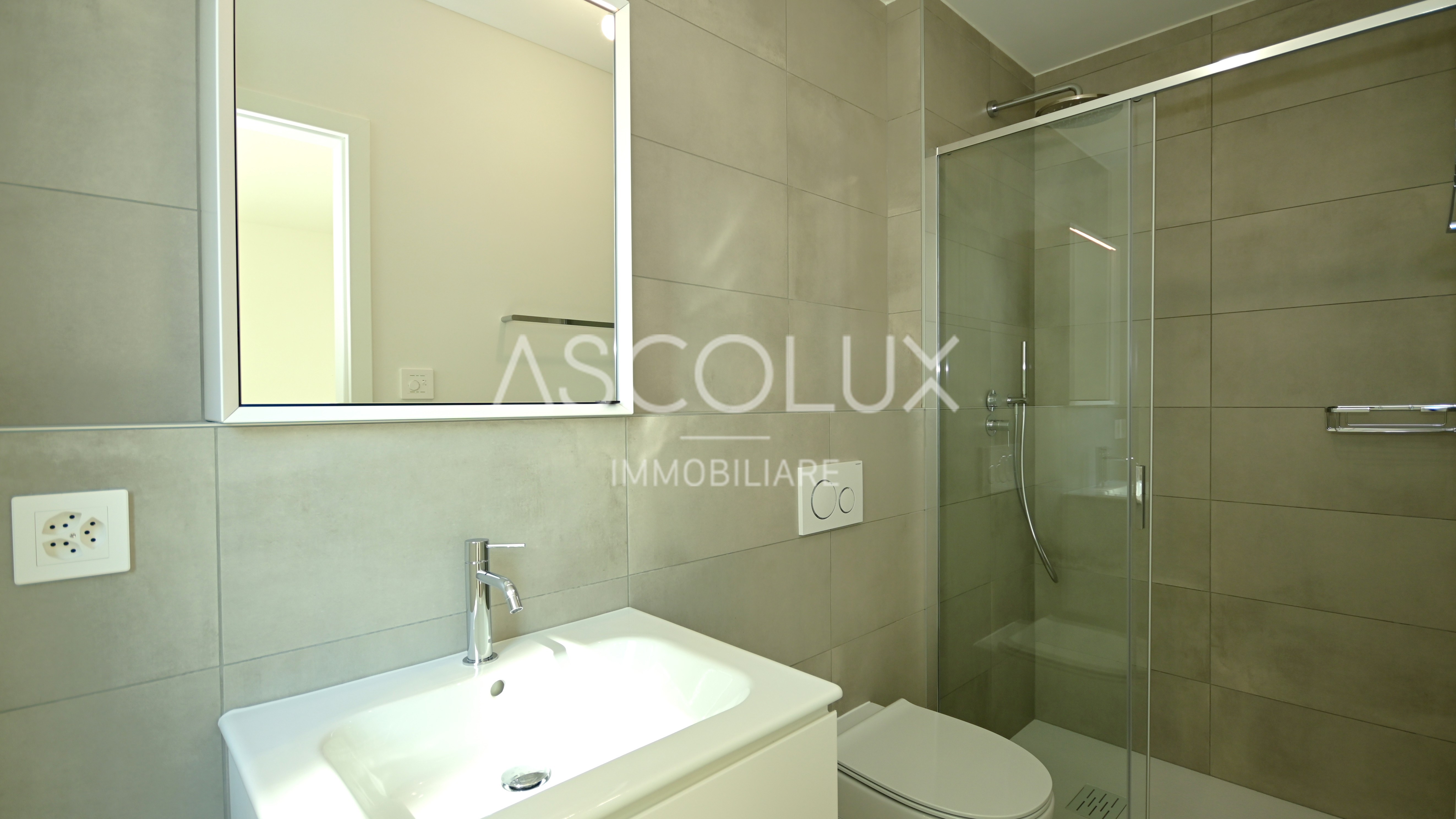 Modernes Badezimmer mit Glasdusche und Waschtisch
