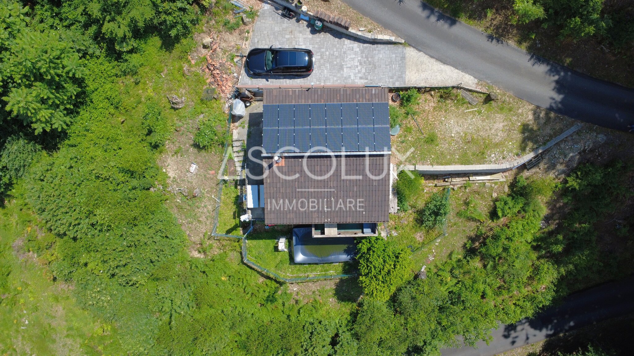 Luftaufnahme eines Hauses mit Solaranlage und Zufahrt