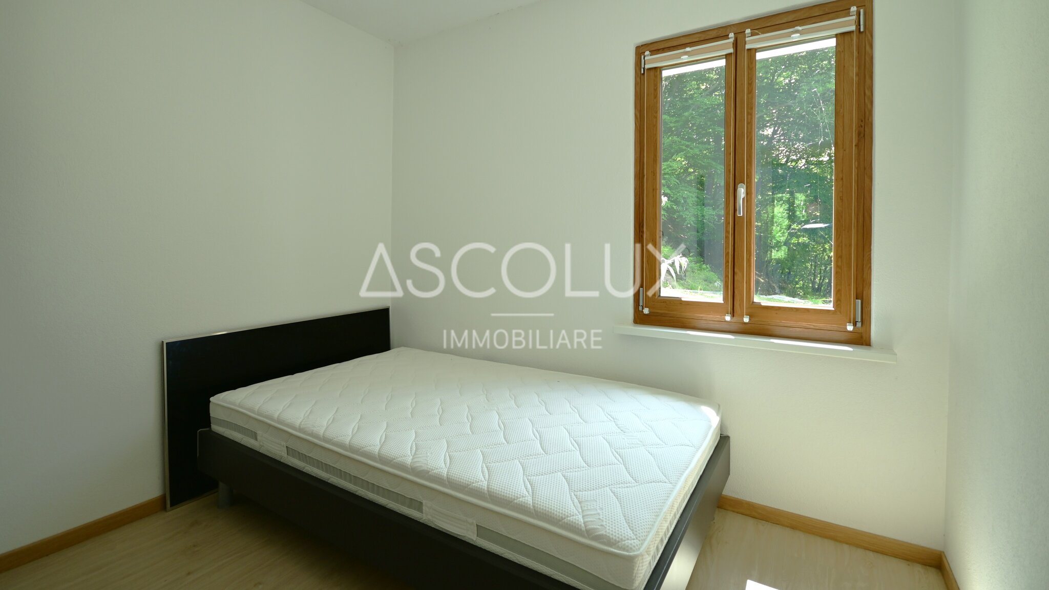 Kleines Schlafzimmer mit Einzelbett und Holzfenster
