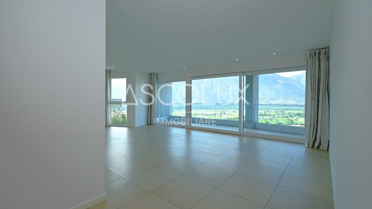 Großer leerer Wohnraum mit Panoramafenstern und Bergblick