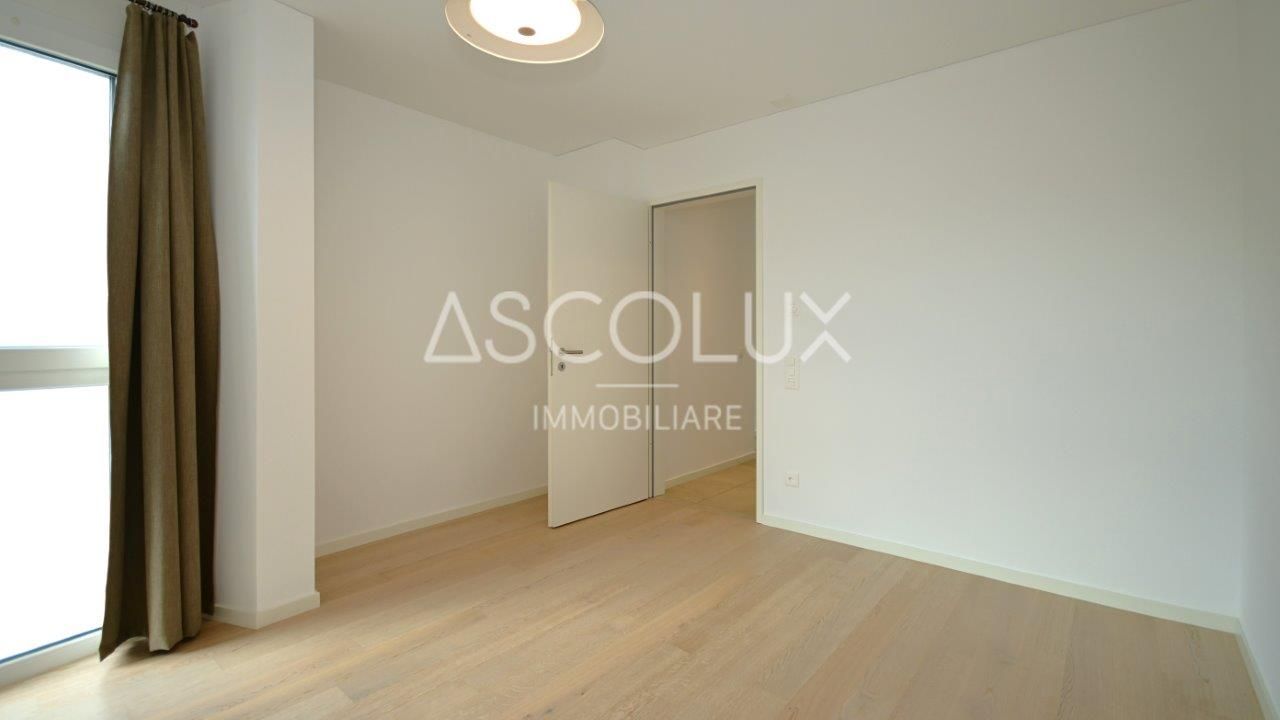 Helles, leeres Zimmer mit Fenster und offener Tür