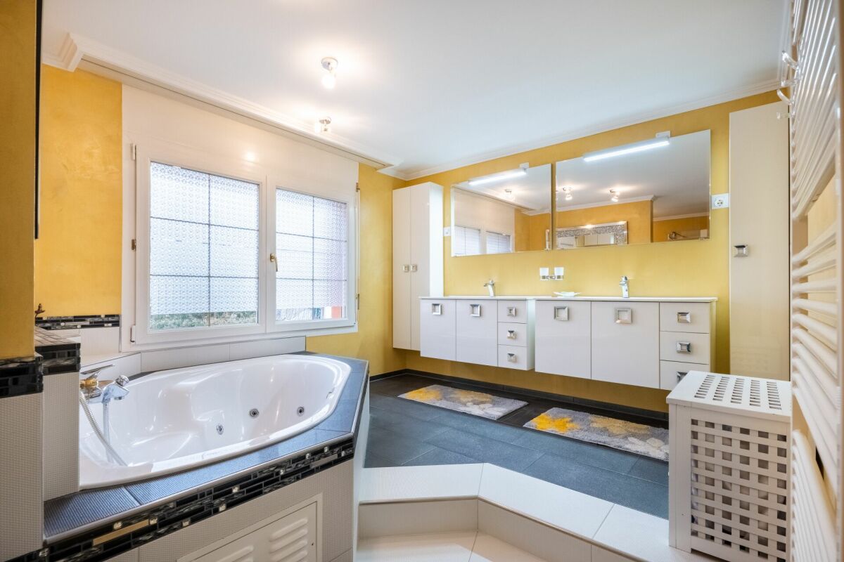 Helles Badezimmer mit großer Badewanne und Doppelwaschtisch