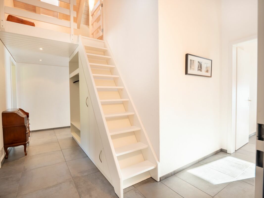 Heller Eingangsbereich mit Treppe und Galerie