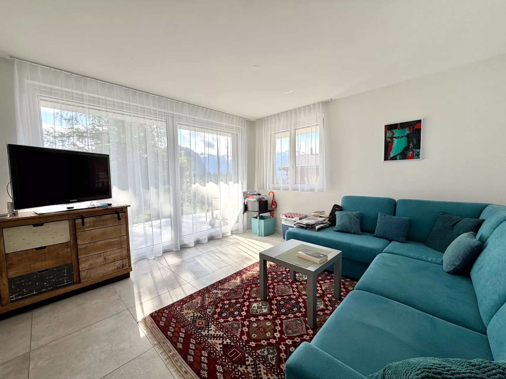 Helles Wohnzimmer mit Ecksofa und Blick ins Freie
