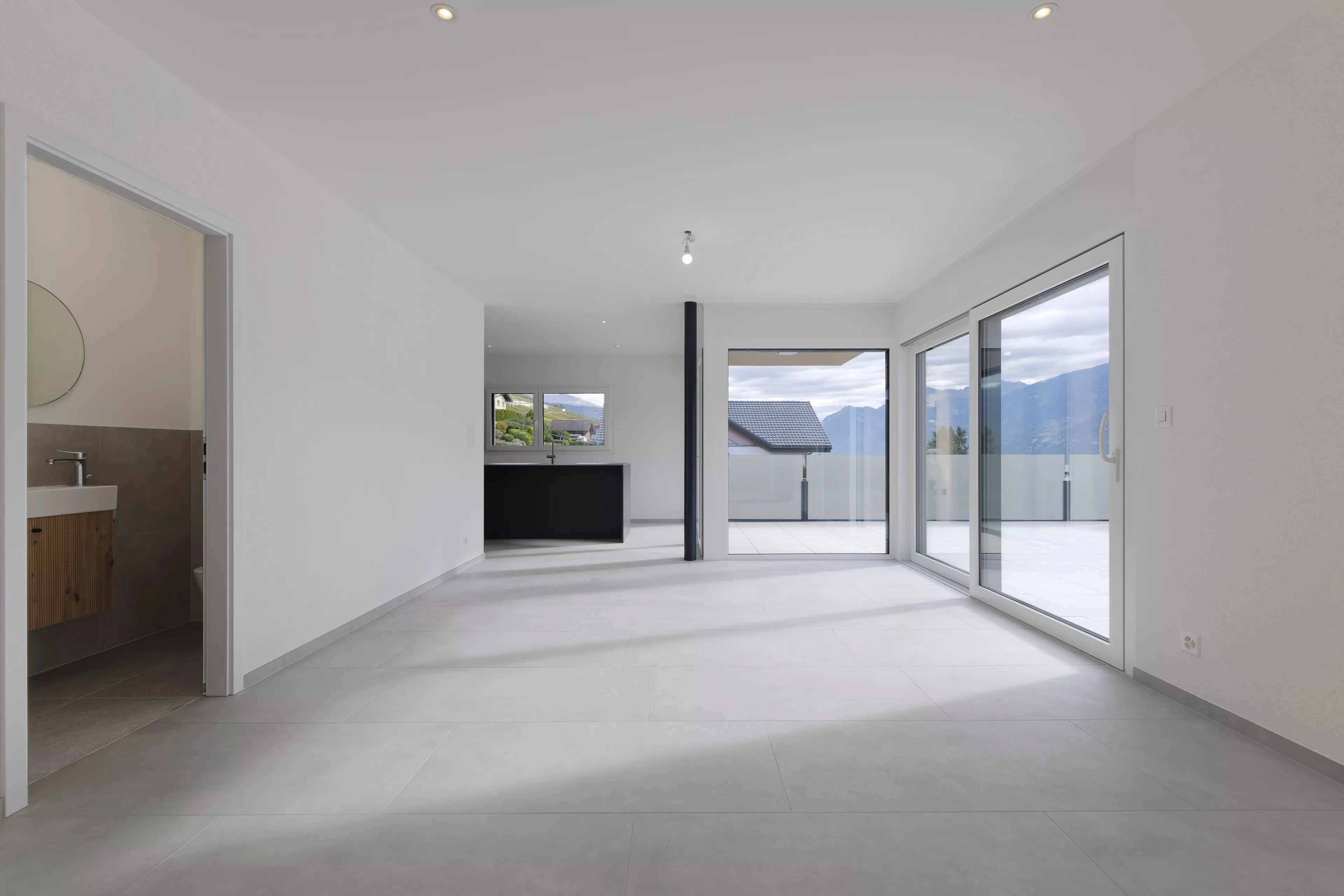 Heller, leerer Wohnbereich mit Terrasse und Bergblick