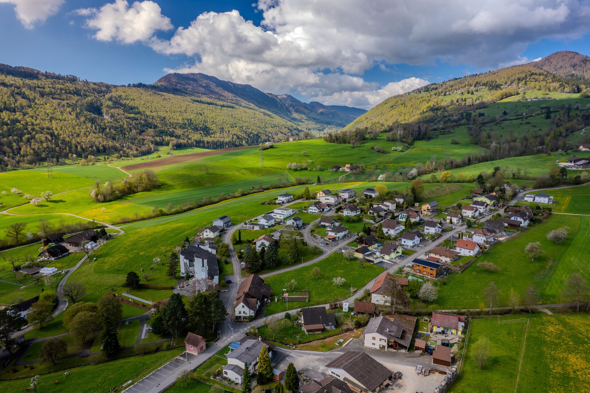 Luftaufnahme eines alpinen Tals mit Ortschaft