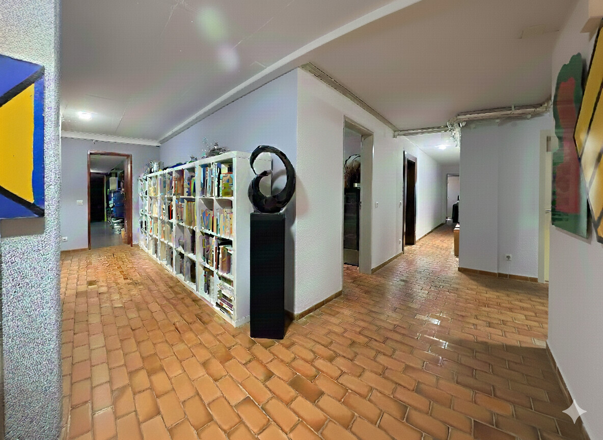 Flur mit Bibliotheksregal und Kunstobjekten