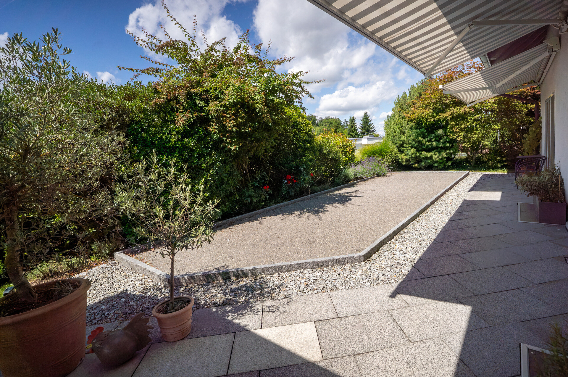 Gepflegter Gartenbereich mit Terrasse und Einfahrt