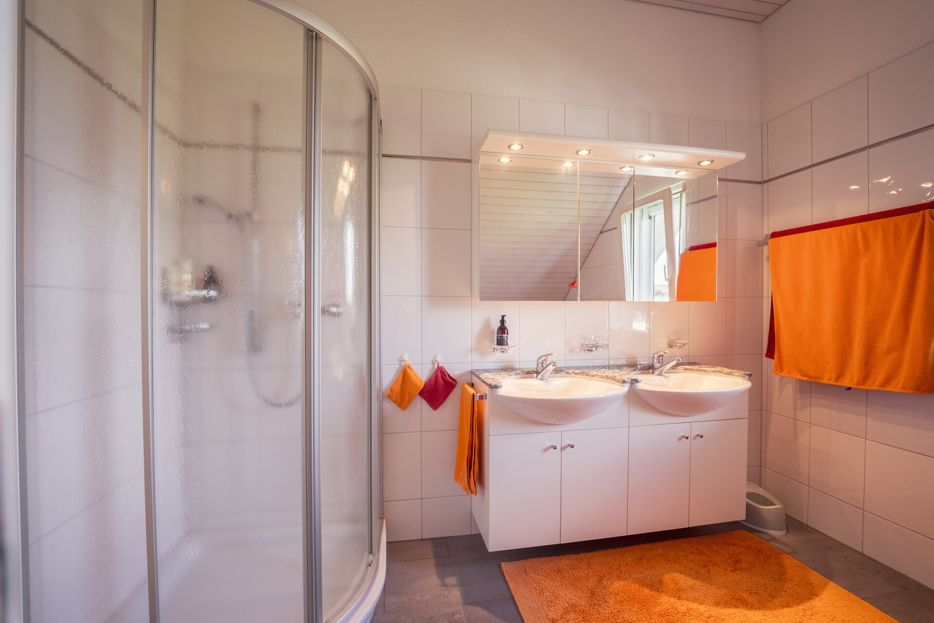 Modernes Badezimmer mit Doppelwaschbecken und Runddusche