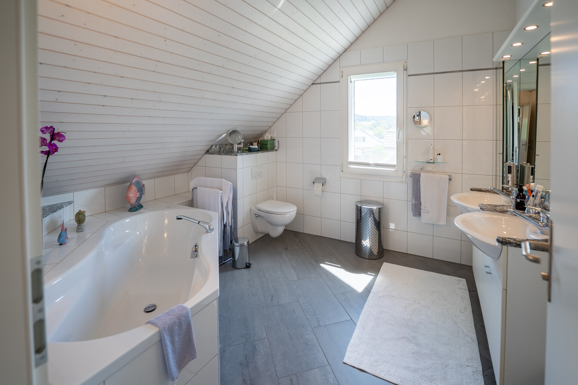 Dachgeschoss-Badezimmer mit Badewanne und Doppelwaschtisch
