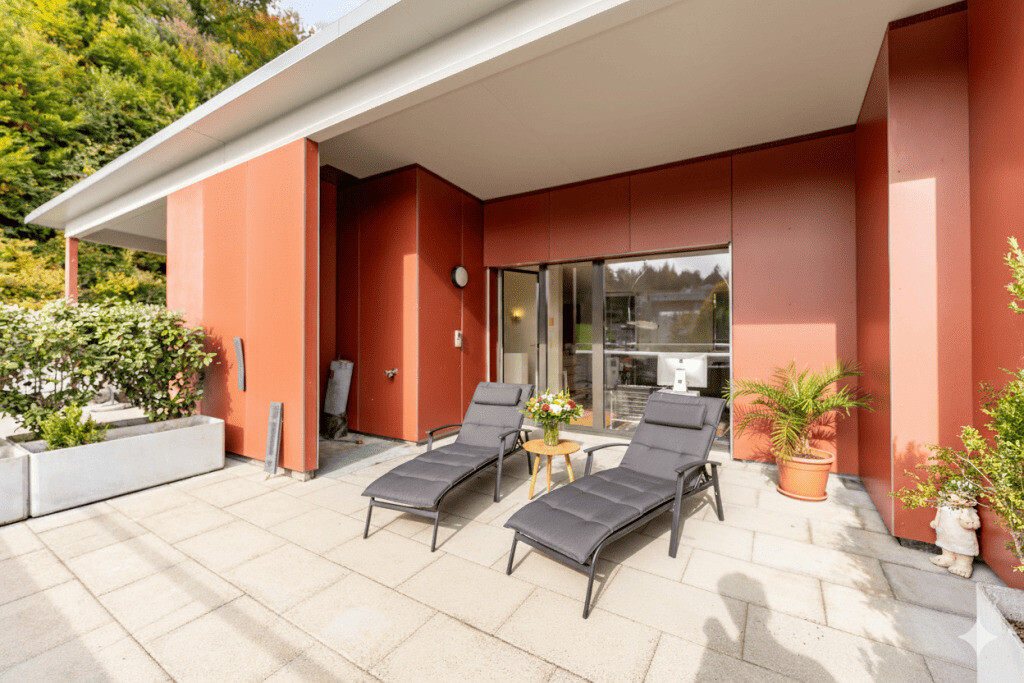 Terrasse mit Liegen vor moderner Fassade