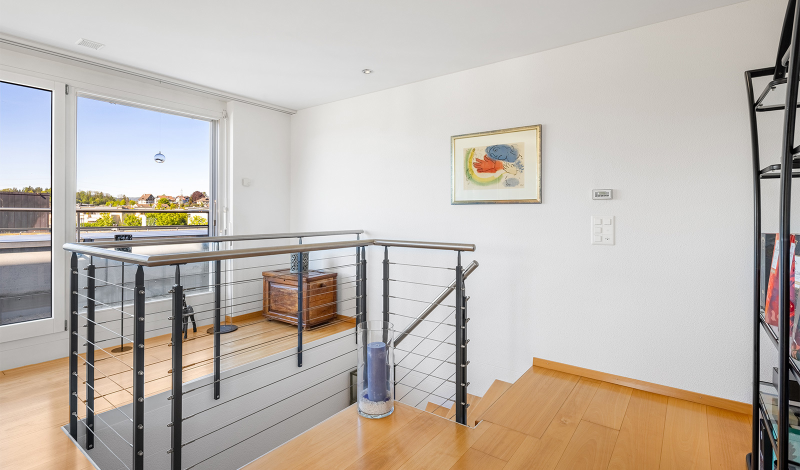 Heller Flurbereich mit Treppe und Balkonblick