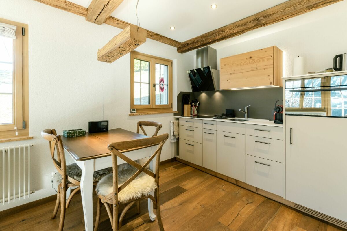 Kleine Küche mit Essbereich und sichtbaren Holzbalken