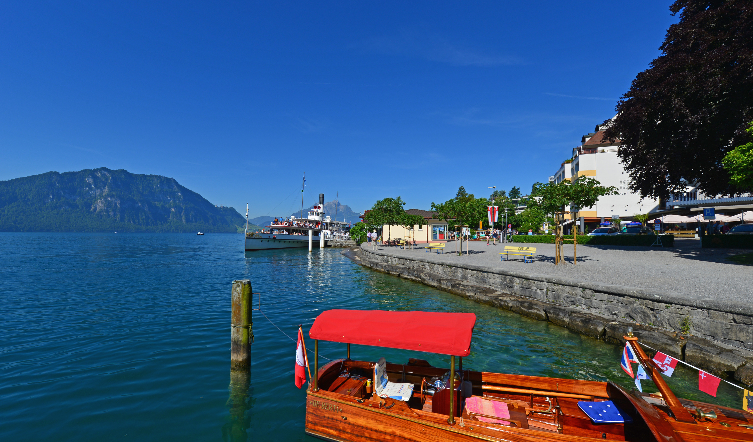 Seeufer mit Bootsanleger und Bergpanorama