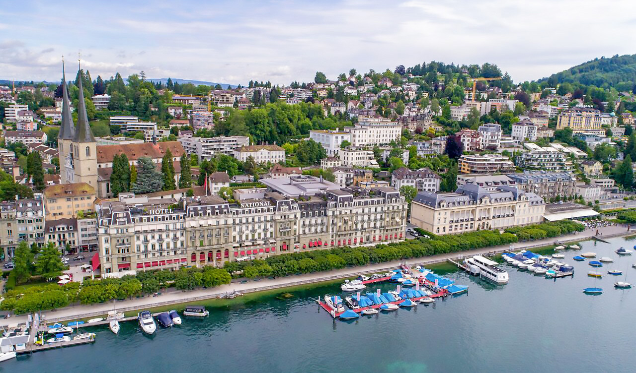 Luftaufnahme einer Seepromenade mit historischer Stadtbebauung