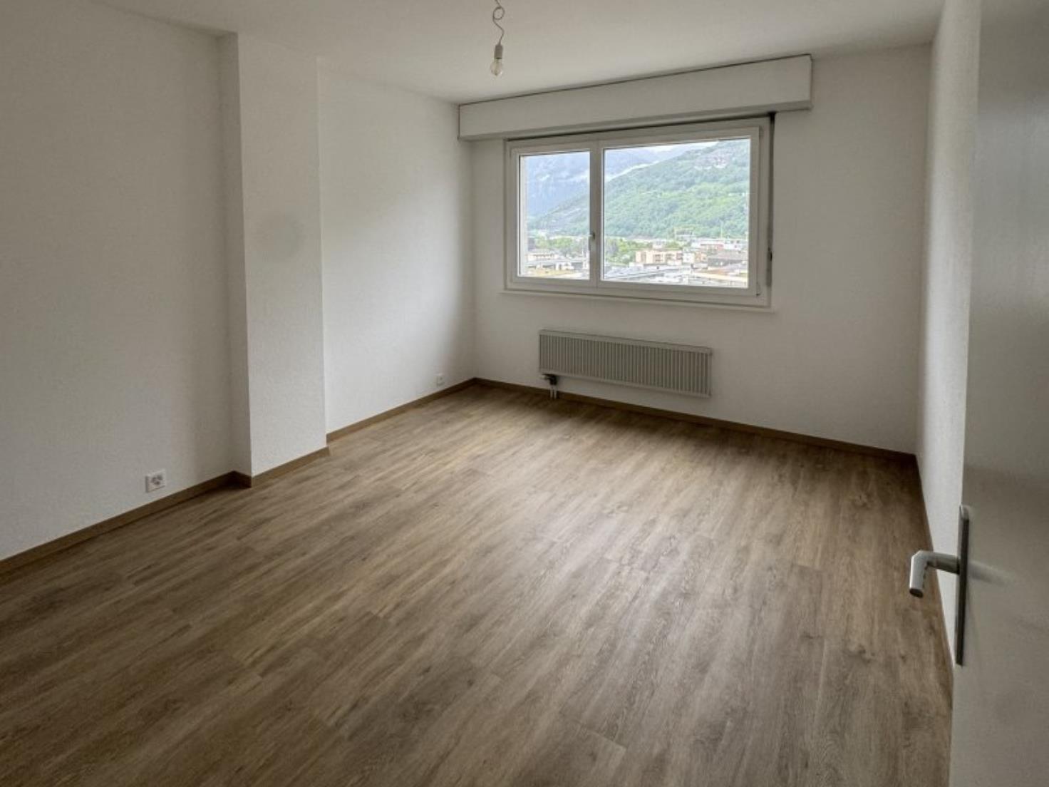 Leerer Wohnraum mit Fenster und Bergblick