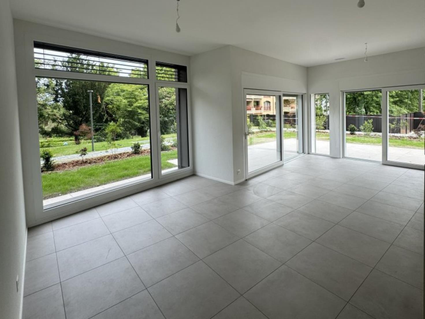 Heller leerer Wohnraum mit großen Fensterfronten