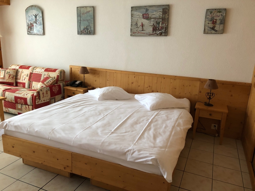 Schlafzimmer mit rustikalem Holzmöbel und Sofa