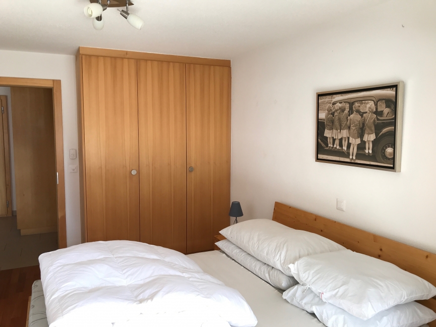 Schlafzimmer mit Holzschrank und Doppelbett