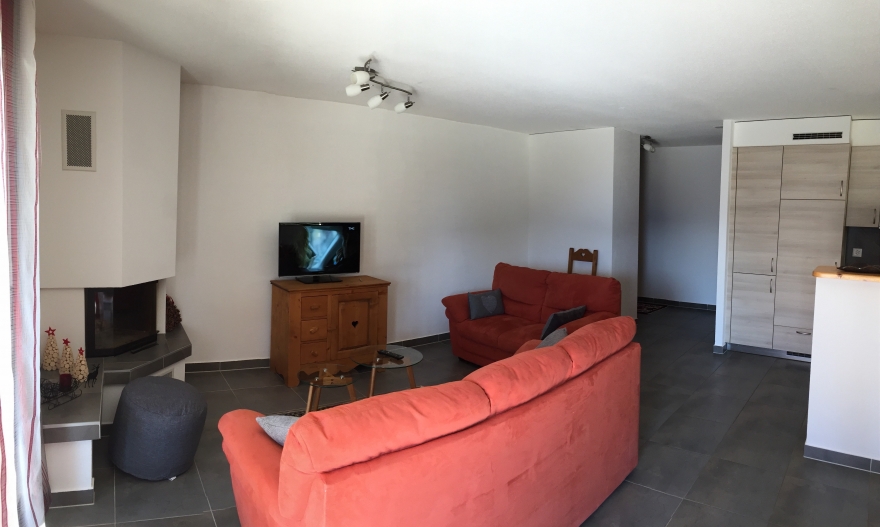 Wohnzimmer mit Kamin und offener Küchenzone