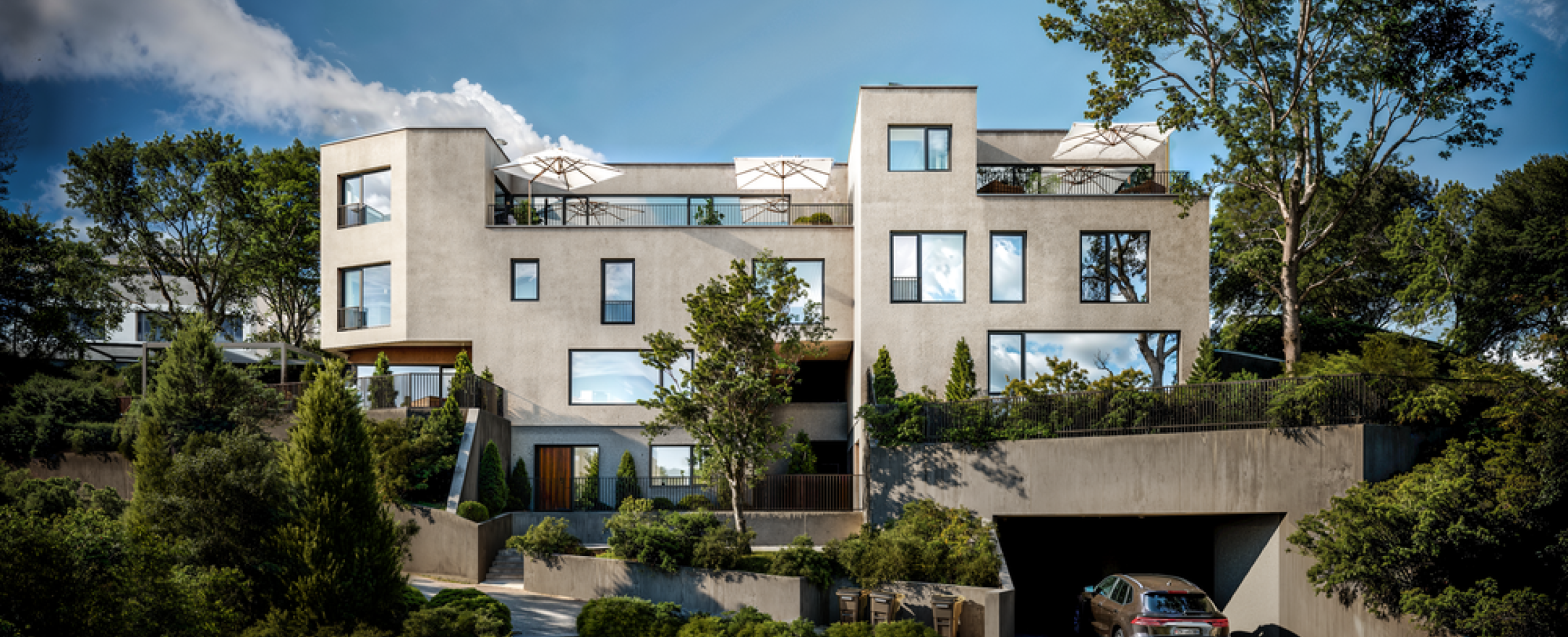 Moderne Villenfassade mit Terrassen und Garagenzufahrt