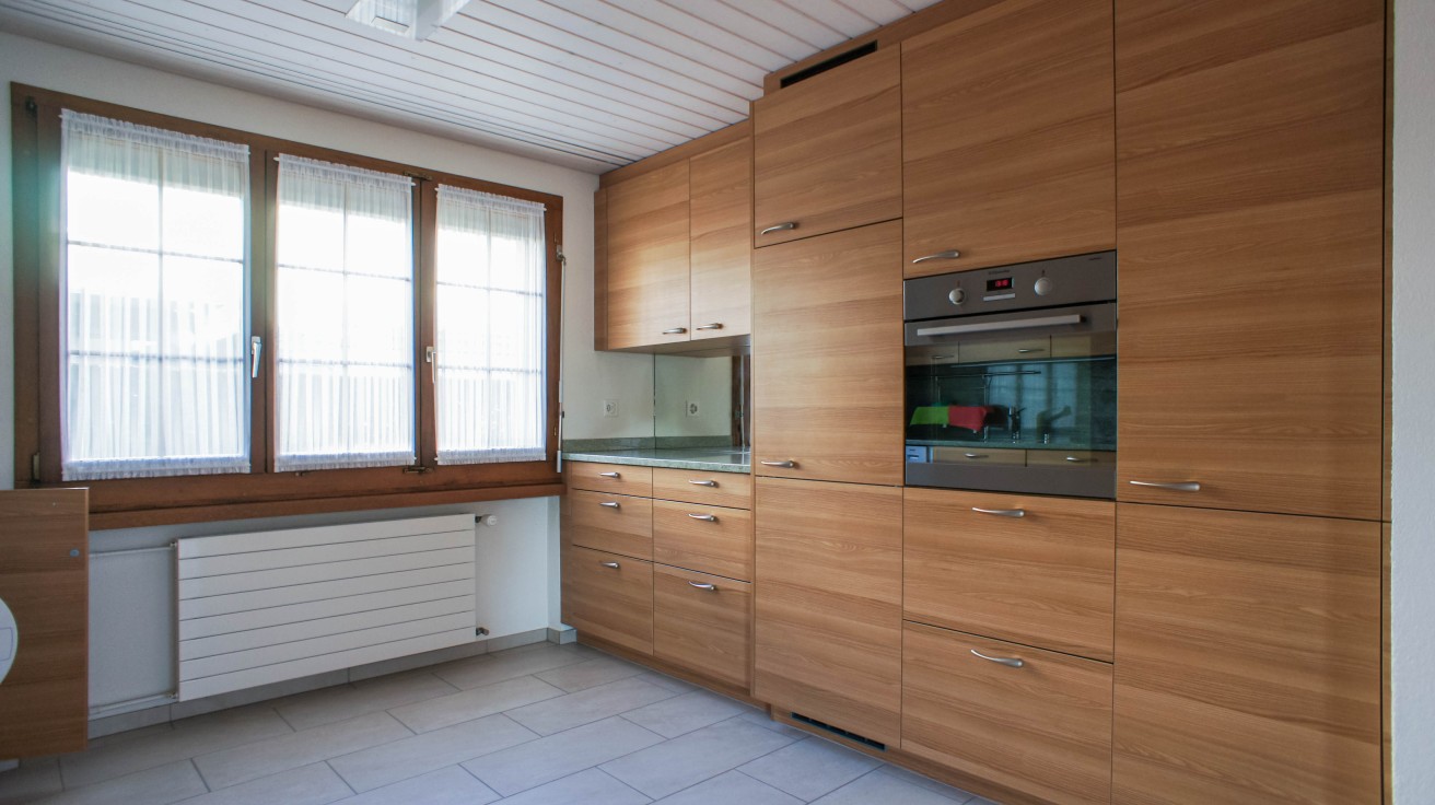 Küche mit Holzfronten und Fensterband