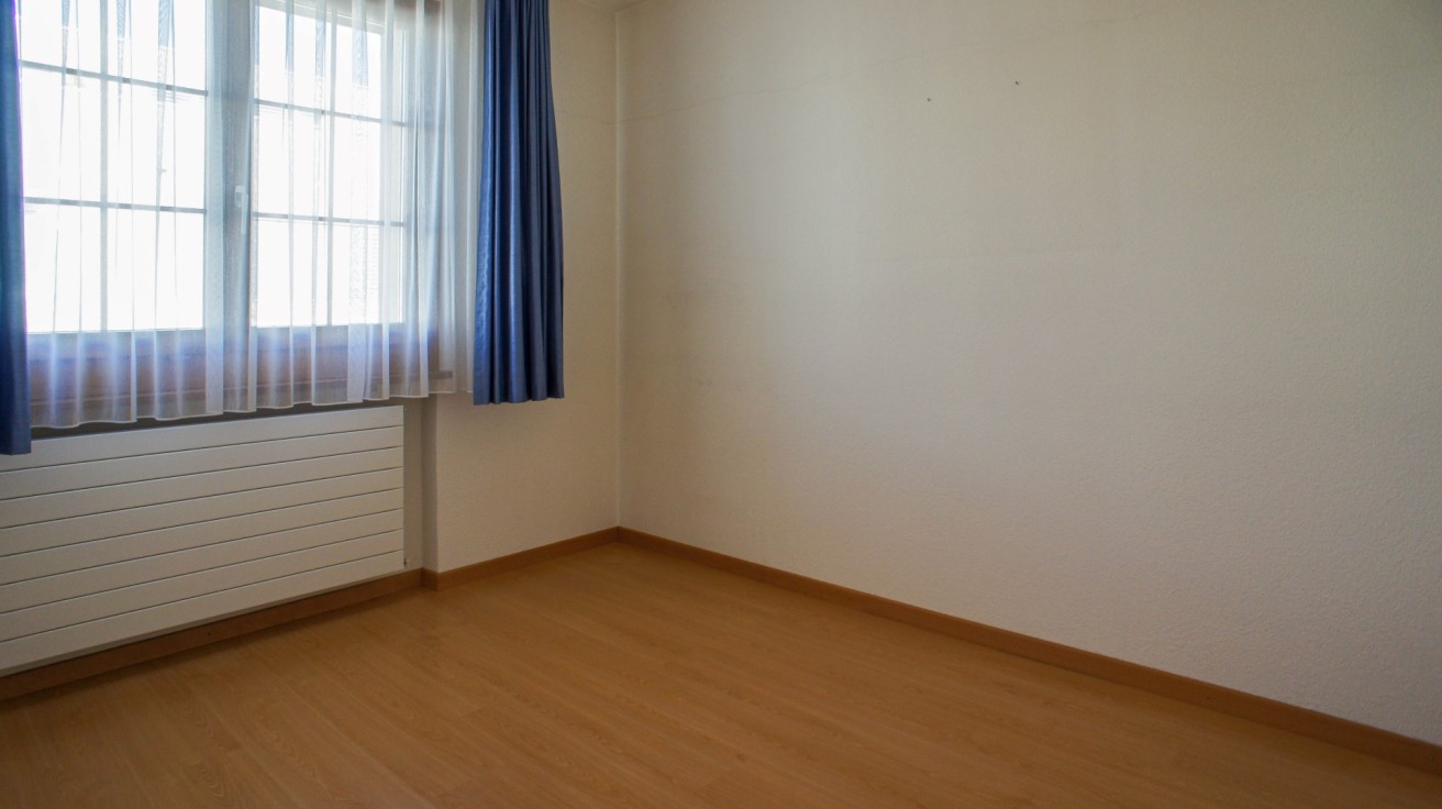 Leerer Wohnraum mit Fenster und Heizkörper